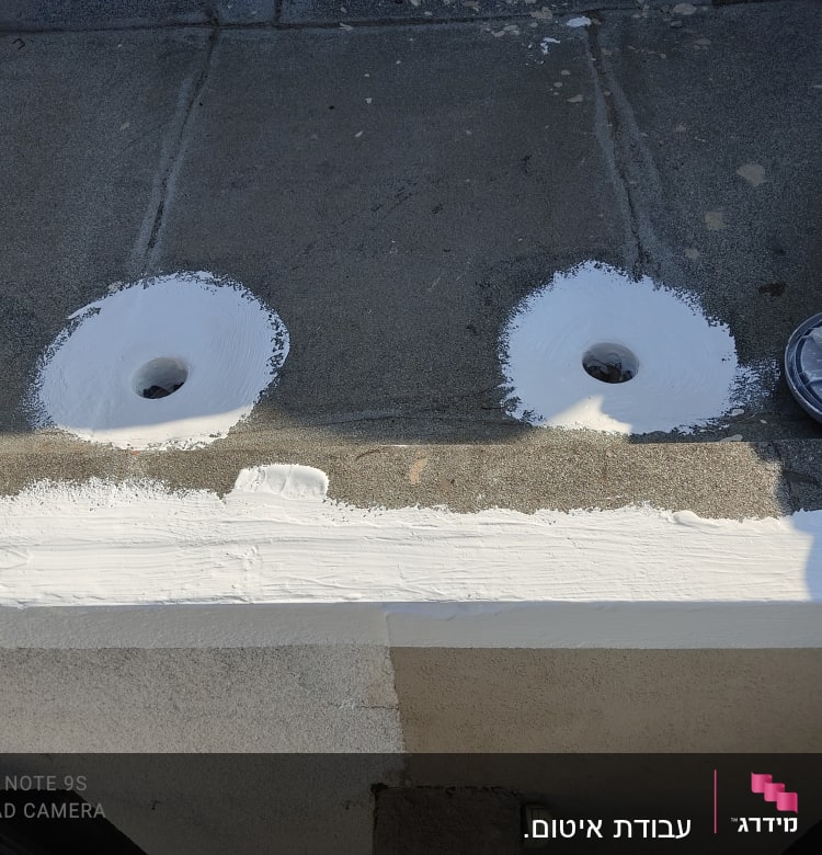 שני חורים אטומים בחומר לבן על גג בטון